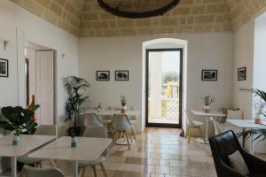 ein Restaurant mit Tischen und Stühlen und einem großen Fenster in der Unterkunft Mastropà Exclusive Resort in Massafra