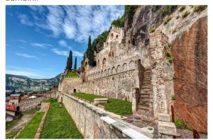 eine Steinmauer mit einer Bank an der Seite in der Unterkunft Beb c’est lavis in Lavis