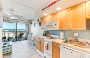 eine Küche mit Holzschränken und Blick auf das Meer in der Unterkunft Long Time No Sea! Direct OCEANFRONT Condo - End Unit Double Ocean View - Crescent Beach, Saint Augustine Florida in Crescent Beach
