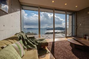 a living room with a couch and a large window at USHIMADO Villa - Vacation STAY 61741v in Setouchi