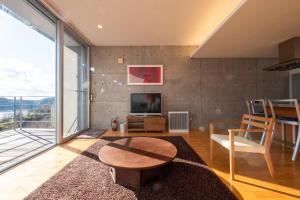 a living room with a table and a tv at USHIMADO Villa - Vacation STAY 61741v in Setouchi