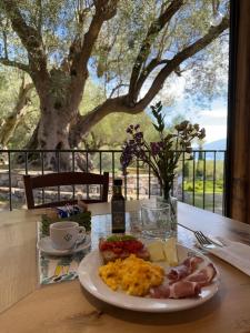 Ein Teller Frühstücksessen auf einem Tisch mit einem Baum in der Unterkunft Pie' d'Ulivo in Bosco