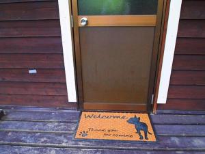 un panneau de bienvenue devant une porte dans l'établissement Foresters Village Kobitto Southern Alps Camp Field - Vacation STAY 78099v, à Shirasu