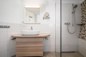 ein Badezimmer mit Waschbecken und Dusche in der Unterkunft Nordkugel - Rundes Wohnglück am Tollensesee in Wustrow + 24 Fotos