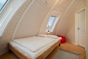 ein Bett in einem Zimmer mit gewölbter Decke in der Unterkunft Nordkugel - Rundes Wohnglück am Tollensesee in Wustrow