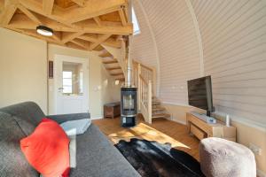 ein Wohnzimmer mit Sofa und Fernseher in der Unterkunft Nordkugel - Rundes Wohnglück am Tollensesee in Wustrow