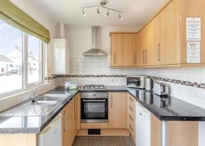 a kitchen with a sink and a stove top oven at Meadow Lakes Holiday Park in St Austell