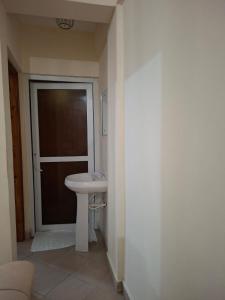 a bathroom with a white sink and a door at Evara Luxe stay in Mombasa