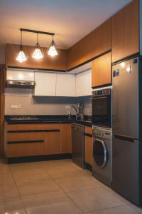 a kitchen with stainless steel appliances and wooden cabinets at Beachfront Apt in Aourir Pool, Surf & Comfort in Aourir