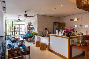 un homme se tient à un comptoir dans un salon dans l'établissement The Sea Koh Samui Resort and Residences by Tolani, à Koh Samui 
