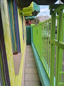 ein grüner Zaun auf einem Gehweg neben einem Gebäude in der Unterkunft Artsy fully equipped 2 bedrooms House all to yourself! in Bukarest