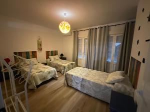 a bedroom with two beds and a chandelier at Casa rural VTAR con piscina in Rosal de la Frontera +48 photos