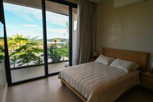 a bedroom with a bed and a large window at Oceanview Home with Pool in Venao in Playa Venao