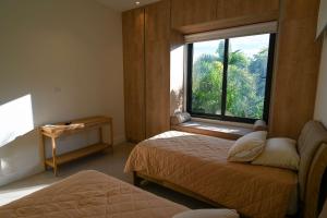 a bedroom with two beds and a large window at Oceanview Home with Pool in Venao in Playa Venao