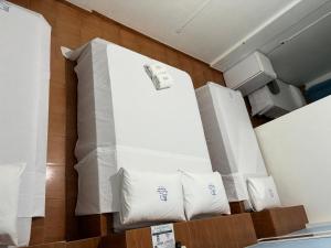 a room with a bed with white sheets and pillows at Hotel Chalé Ji-Parana in Ji-Paraná