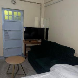 un salon avec un canapé, une table et une télévision dans l'établissement Lawrence place, à Nairobi