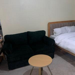 une pièce avec un canapé, un lit et une table dans l'établissement Lawrence place, à Nairobi