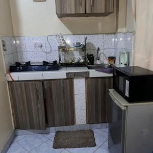 une petite cuisine avec un évier et un micro-ondes dans l'établissement Lawrence place, à Nairobi