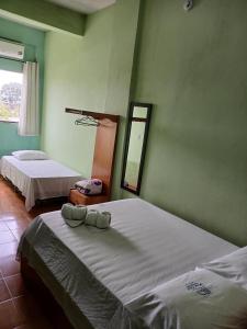 a bedroom with two beds and a mirror in it at Hotel Chalé Ji-Parana in Ji-Paraná