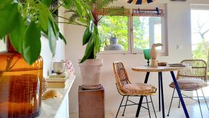 ein Zimmer mit einem Tisch, Stühlen und einer Pflanze in der Unterkunft CoCo Cabin Luxe Tiny House - Privé Hottub - Strand & zwemvijver - Privacy in Woudenberg