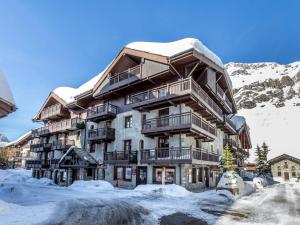 un grand bâtiment recouvert de neige dans l'établissement Appartement de charme avec balcon, 8 pers, décor raffiné, au cœur de Val-d’Isère, proche des pistes - FR-1-694-106, à Val dʼIsère