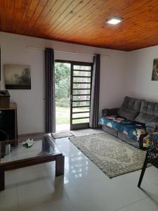 a living room with a couch and a table at Loft Campos a 12 minutos do centro turistico de Campos do Jordão in Campos do Jordão +73 photos