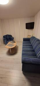 a living room with a blue couch and a table at Pas Dianą 1 aukštas in Jurbarkas