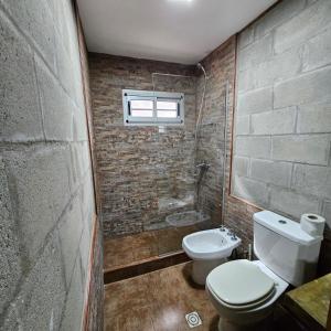 een badkamer met een toilet en een douche bij Gorriones Libres in Villa Gesell