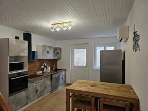 a kitchen with a stainless steel refrigerator and a wooden table at Gîte entre vigne et loire in Sancerre +5 photos