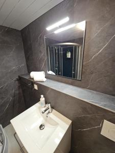 un baño con lavabo y espejo en Apartment Eiger - Aare Jungfrau AG, en Grindelwald 12 fotos más