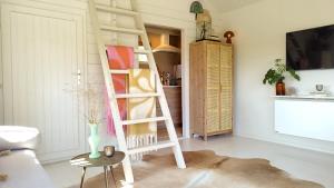 ein Zimmer mit einer Leiter und einer Vase auf einem Tisch in der Unterkunft CoCo Cabin Luxe Tiny House - Privé Hottub - Strand & zwemvijver - Privacy in Woudenberg