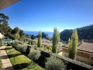 a view of a garden with olive trees at Modern Luxury - Sea View over Èze Village in Èze