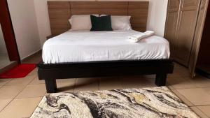a bedroom with a large bed with a wooden headboard at BARAN Home in Yaoundé