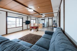 ein großes blaues Sofa in einem Wohnzimmer mit einem Tisch in der Unterkunft KING DEER - Vacation STAY 67718v in Higashikawa