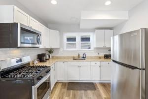 a kitchen with white cabinets and a stainless steel refrigerator at 3 BD 2 BA Home near Ohare Airport sleeps 8 in River Grove