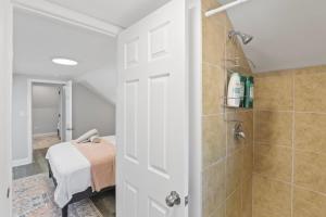 a bathroom with a shower and a bed in a room at 3 BD 2 BA Home near Ohare Airport sleeps 8 in River Grove +15 photos