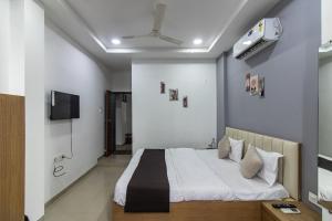 Un dormitorio con una cama y un televisor en la pared. en Hotel NS Premium, en Nagpur