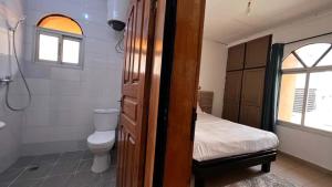 a bathroom with a bed and a toilet and a sink at BARAN Home in Yaoundé +26 photos
