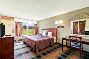 a hotel room with a bed and a desk at Hotel O Star Motel Hattiesburg HWY 49 in Hattiesburg