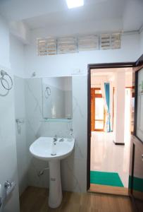 a white bathroom with a sink and a mirror at Ella Ninestars Lodge in Ella +39 photos