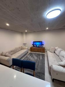 a living room with couches and a flat screen tv at Innsbruck West in Inzing
