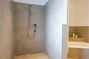 a bathroom with a shower and a tub at Haus Dippel am Kurpark inklusive Chiemgaukarte in Ruhpolding +38 photos