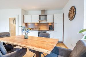 a kitchen and dining room with a wooden table and chairs at Haus Dippel am Kurpark inklusive Chiemgaukarte in Ruhpolding +68 photos