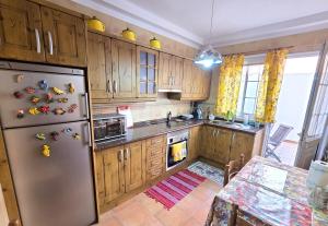 eine Küche mit Holzschränken und einem Edelstahlkühlschrank in der Unterkunft VV Zumacal La Palma in San Antonio