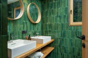 a green tiled bathroom with a sink and two mirrors at bläkat in Ramsau im Zillertal +37 photos