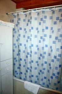 ducha con cortina azul y blanca en Apartamentos El Cuetu, en Llanes