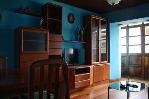 sala de estar con TV y mesa de comedor en Apartamentos El Cuetu, en Llanes