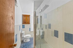 a bathroom with a toilet and a glass shower at 4 Bedroom full house with 4 car parking in Kingston +36 photos