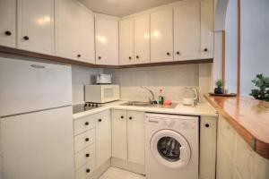 una cocina con lavadora y fregadero en Casa Rita, en La Mata