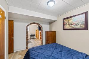 a bedroom with a blue bed and an archway at 4 Bedroom full house with 4 car parking in Kingston
